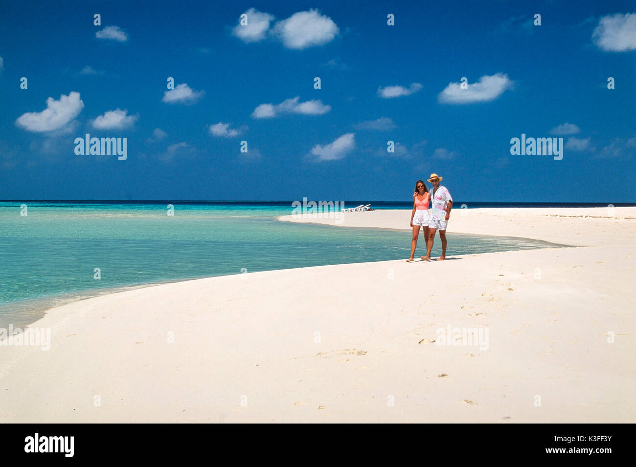 La pareja va a dar un paseo del brazo en una solitaria playa (Maldivas) Foto de stock