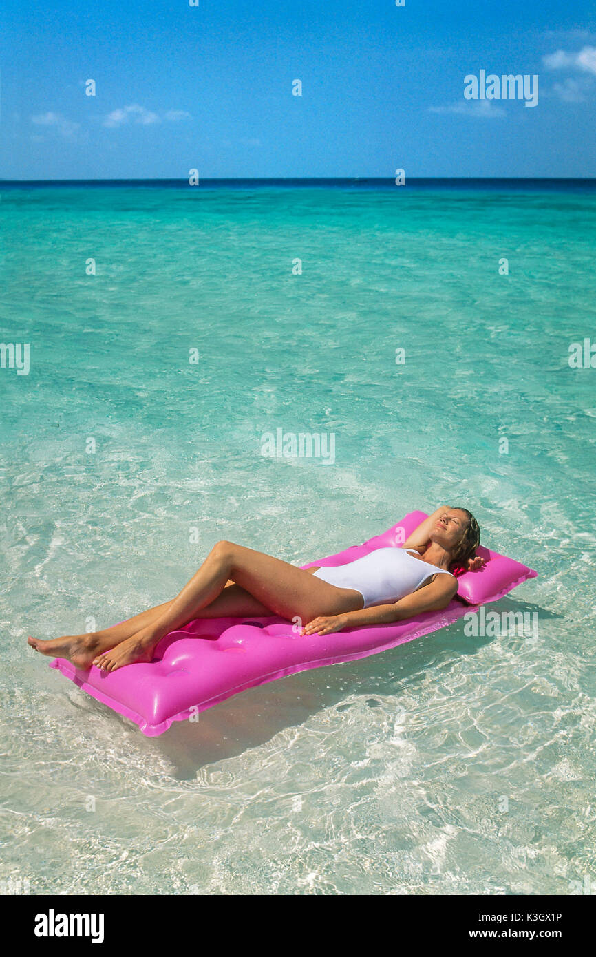 Mujer en el aire en la cama del mar Foto de stock