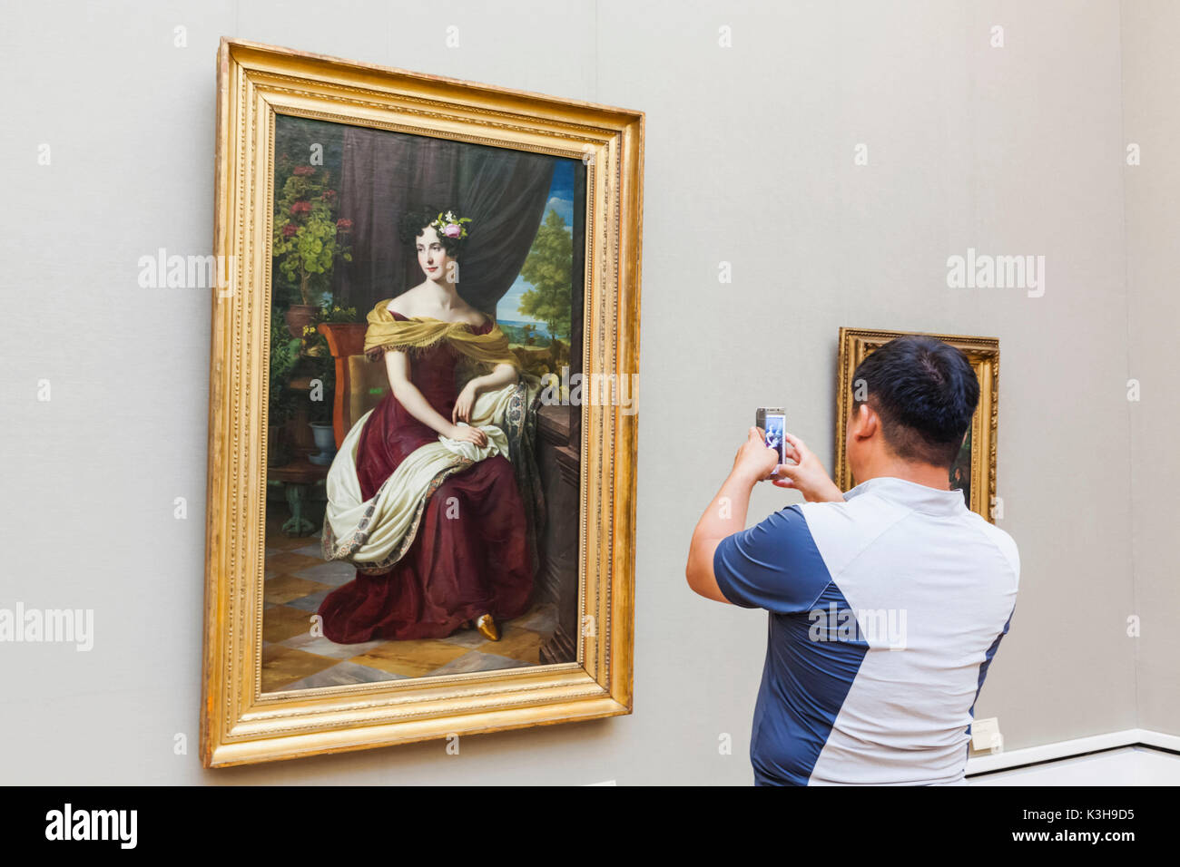 Alemania, Baviera, Munich, la Nueva Pinacoteca Museo (Neue Pinakothek), visitante toma de fotografía de obras de arte con el iPhone Foto de stock