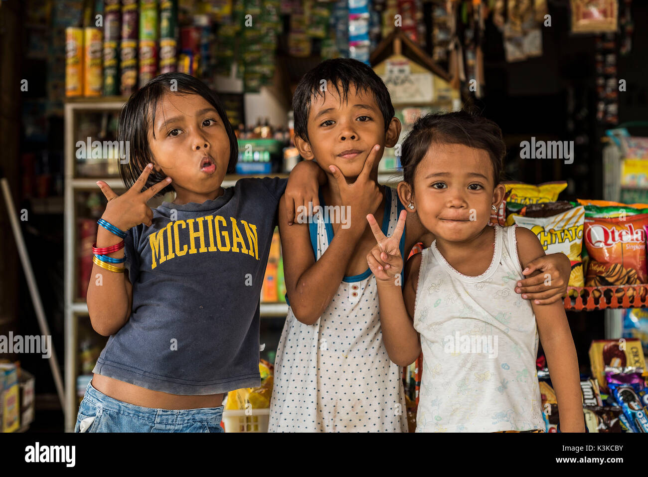 Tres niños posar delante de un quiosco en Bukit Lawang, Indonesia. Foto de stock