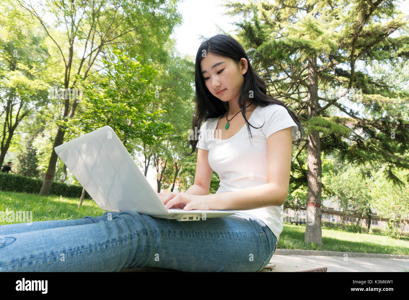 Bella asiática estudiante universitario con el portátil al aire libre Foto de stock
