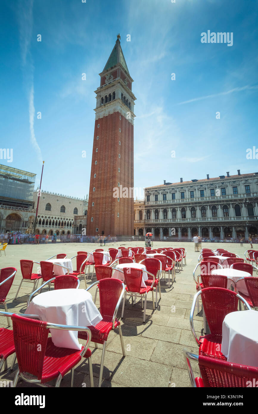 Europa, Italia, Veneto, Venecia. El campanario y la plaza de San Marcos con las sillas y mesas de café Foto de stock