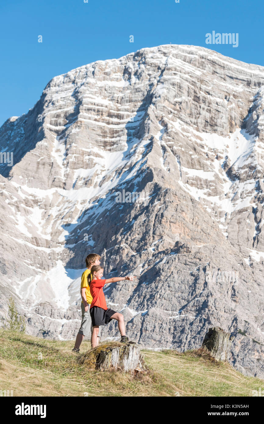 La Valle / Wengen, Alta Badia, provincia de Bolzano, Tirol del Sur, Italia. Los niños admirar el paisaje montañoso de Pra den Rit Foto de stock