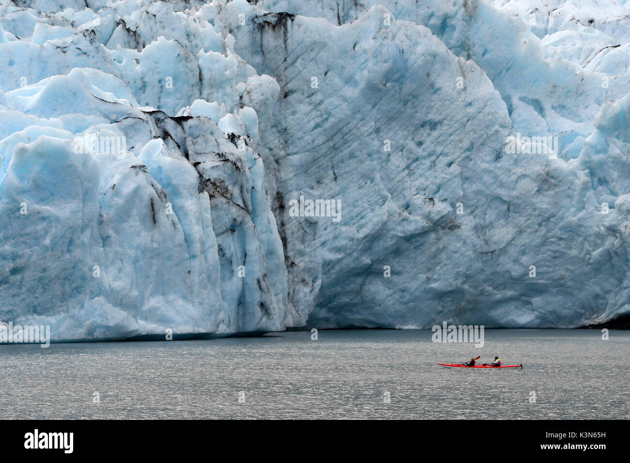 Kayak canoa (roja) cerca de la parte frontal del glaciar, glaciar Portage, Alaska, EE.UU. Foto de stock