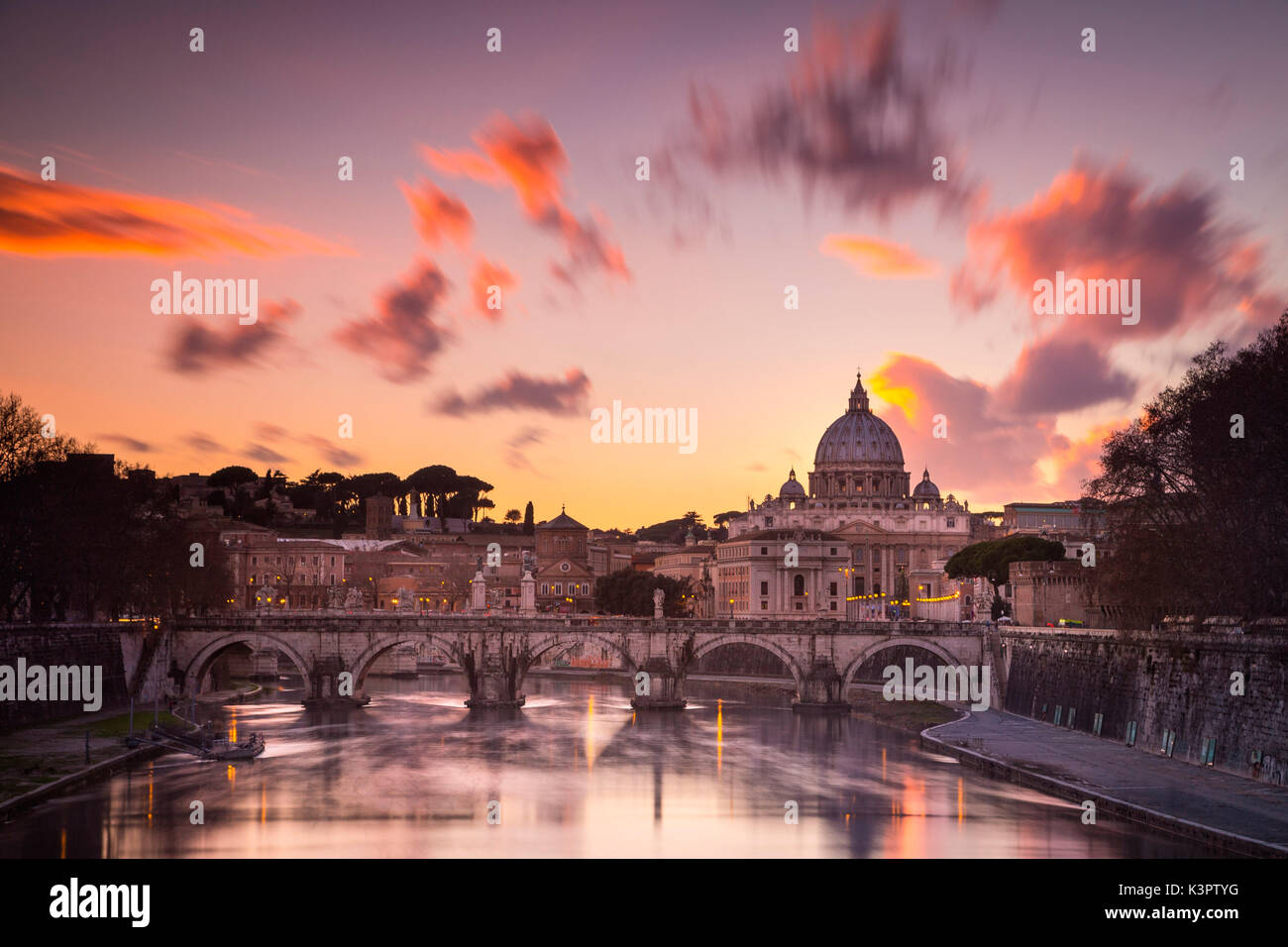 Roma, Lazio, Italia. Puesta de sol sobre el río Tevere, con la Catedral de San Pedro en el fondo. Foto de stock