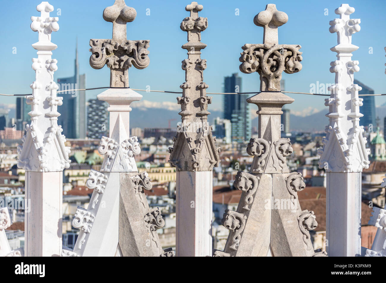 El mármol blanco spiers del Duomo frame los rascacielos de Milan Italia Europa Foto de stock