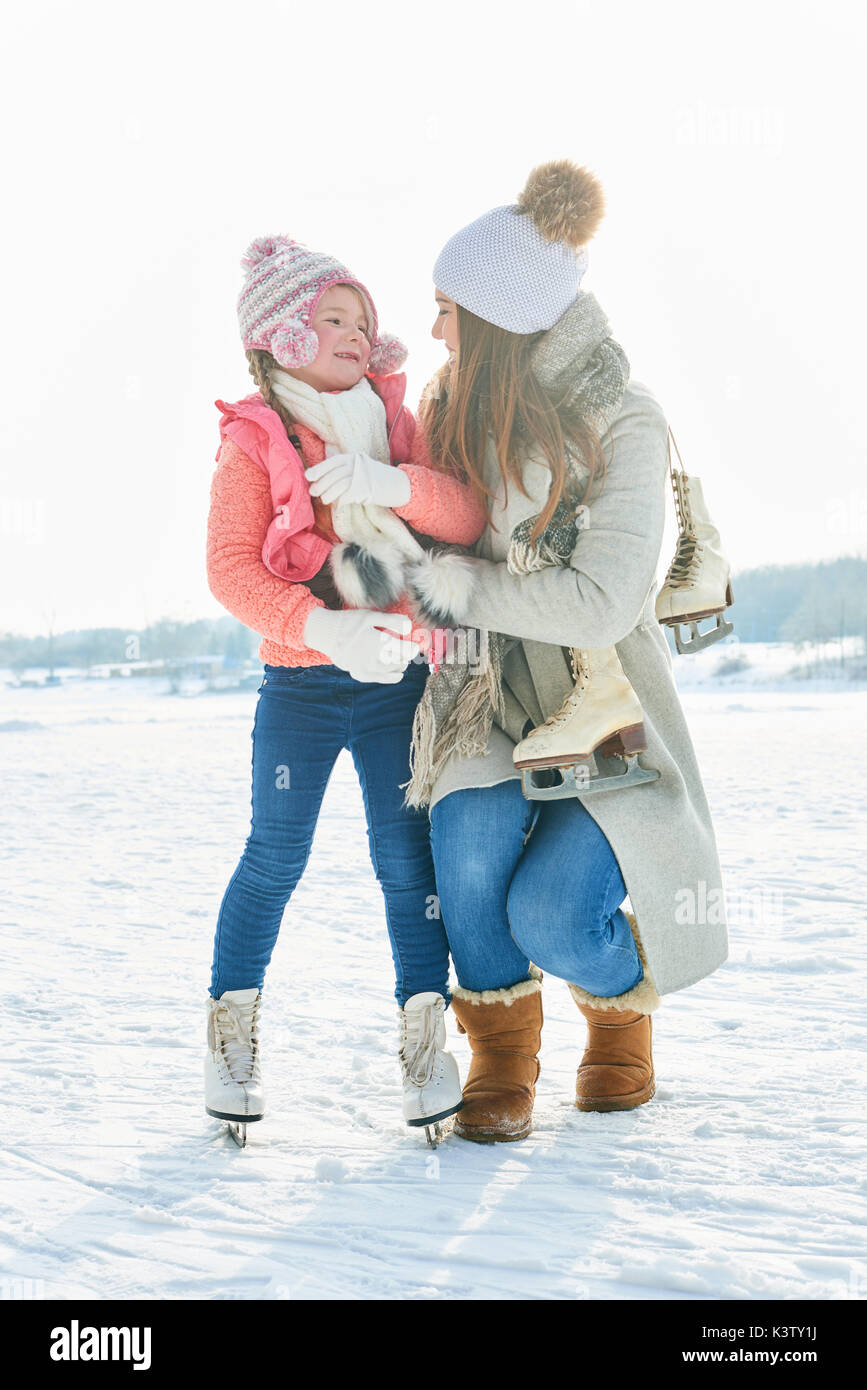 Madre e hija juntas en invierno con patines de hielo. Foto de stock