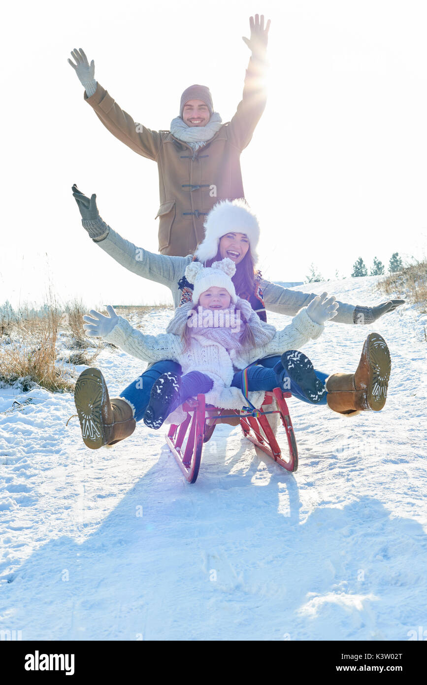 Familia con entusiasmo jugar con el trineo en invierno Foto de stock
