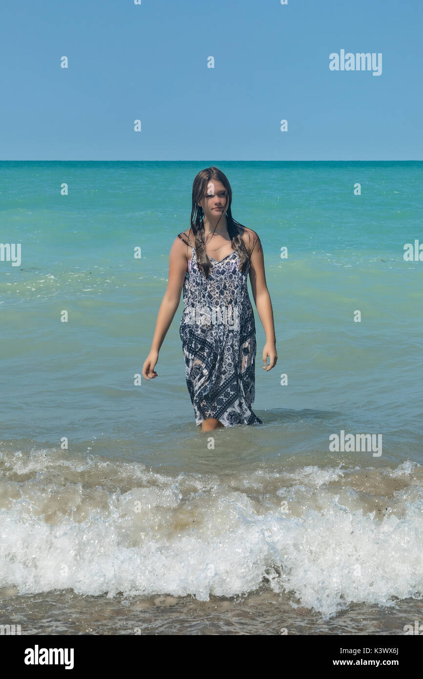 Una niña de pie en un lago en las ondas Foto de stock