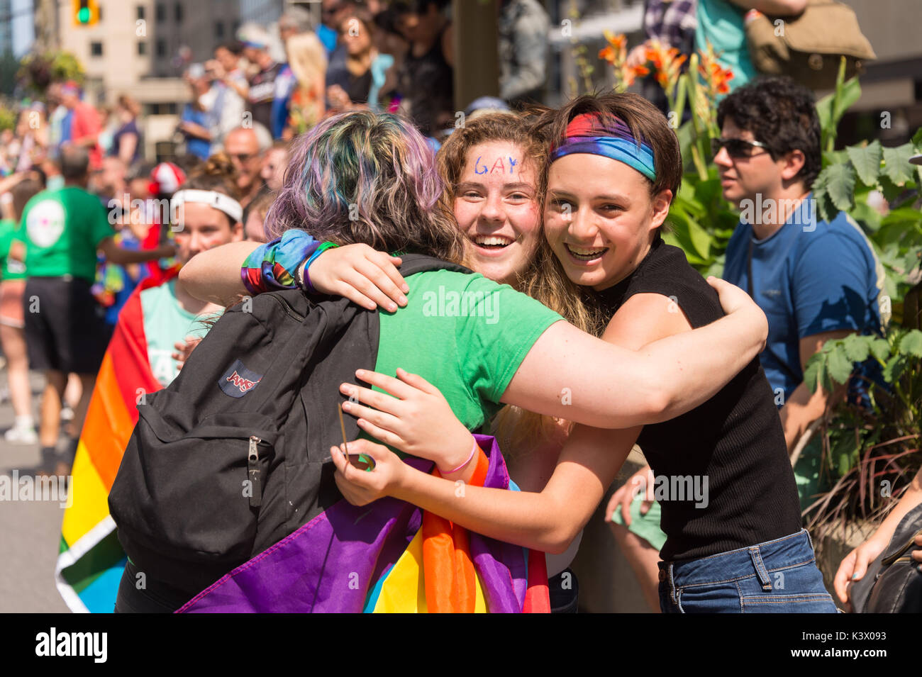 Montreal, Canadá - 20 de agosto de 2017: 3 personas abrazarse mutuamente en Montreal Desfile del Orgullo Gay Foto de stock