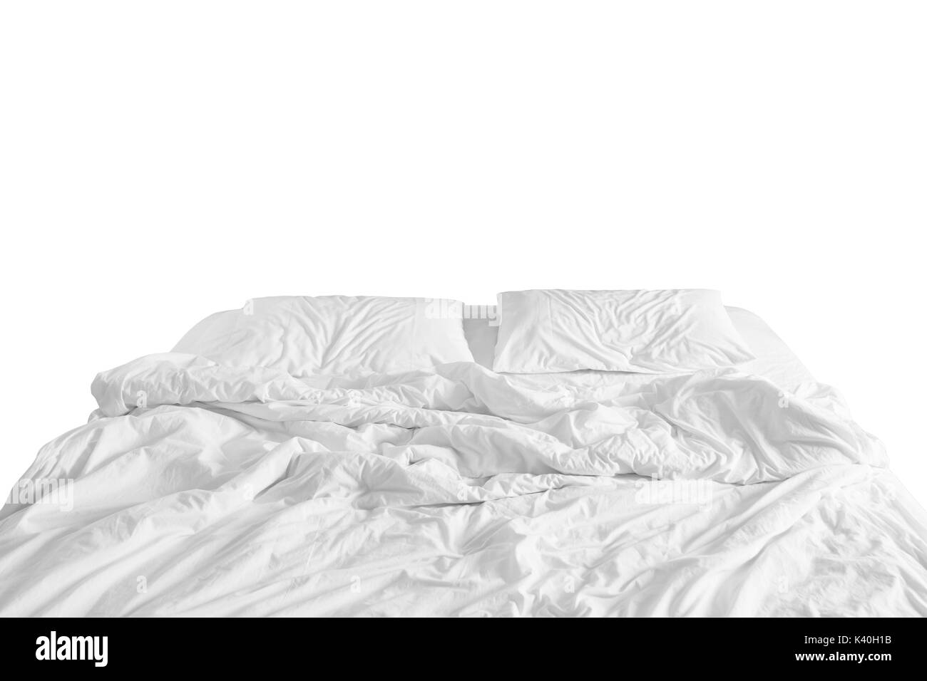 Deshacen la cama con sábana arrugado, una manta y almohadas Confort edredón dormir después de despertarse en la mañana. Foto de stock