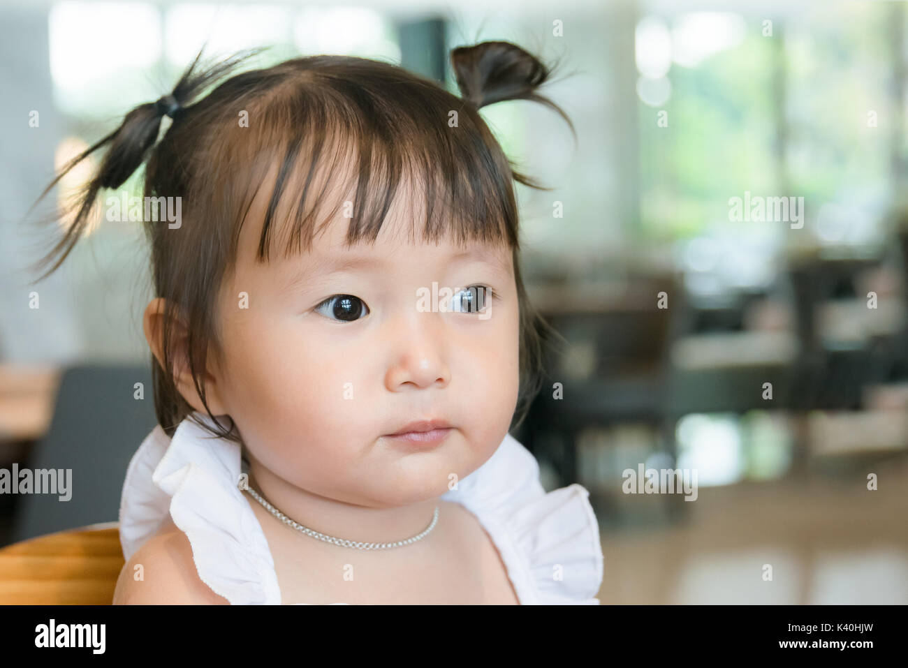 Retrato de niña de 2 años, enfrenta cara sonriente en el fondo con el espacio interior Foto de stock