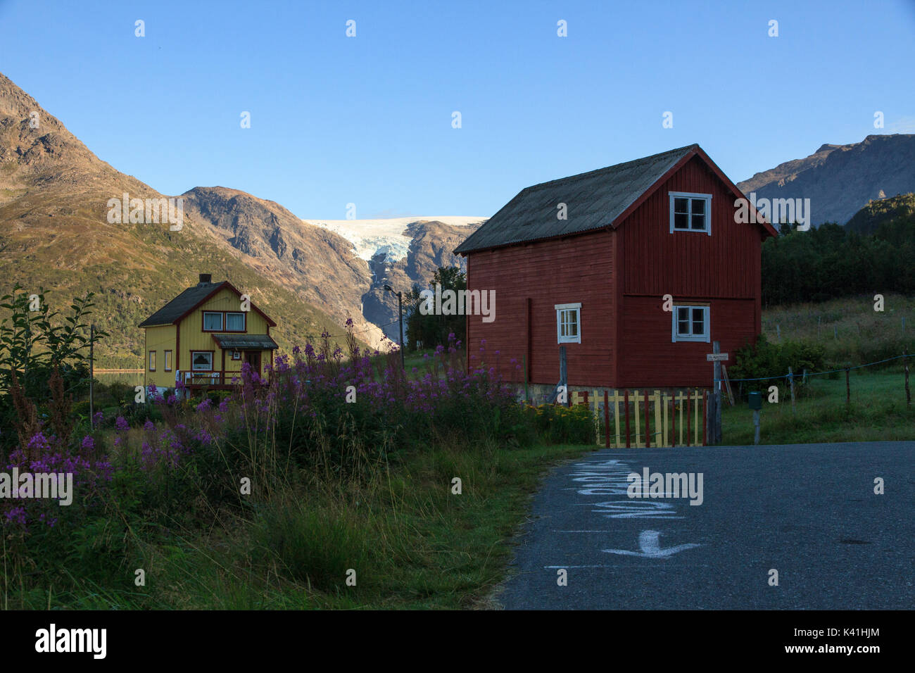 Casas tradicionales en el norte de Noruega con el ventisquero colgante de jokelfjord en la parte trasera del terreno Foto de stock