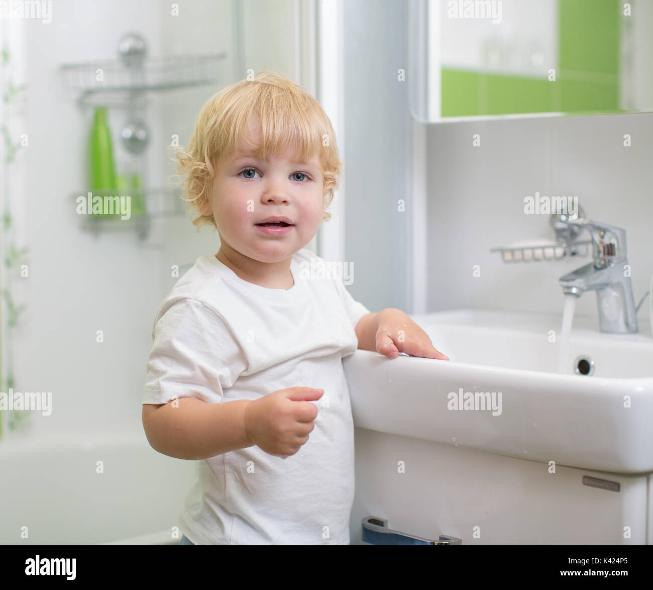 Kid el lavado de manos en el baño. Foto de stock