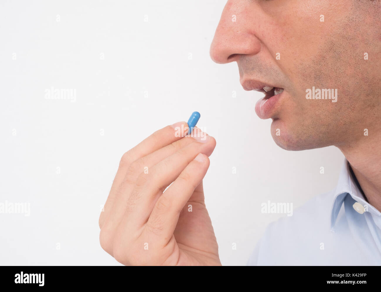 Cabeza de hombre enfermo comer medicina píldora azul Foto de stock