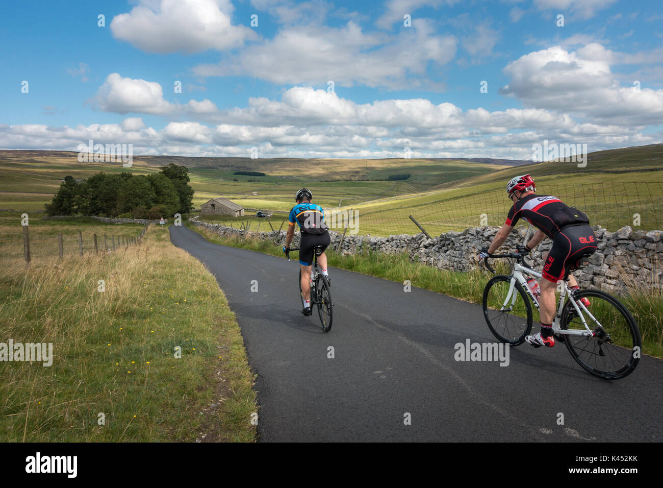 El paisaje del Reino Unido. Dos ciclistas masculinos Malham Moor hacia Littondale descendente en la hermosa campiña de Yorkshire Dales. Foto de stock