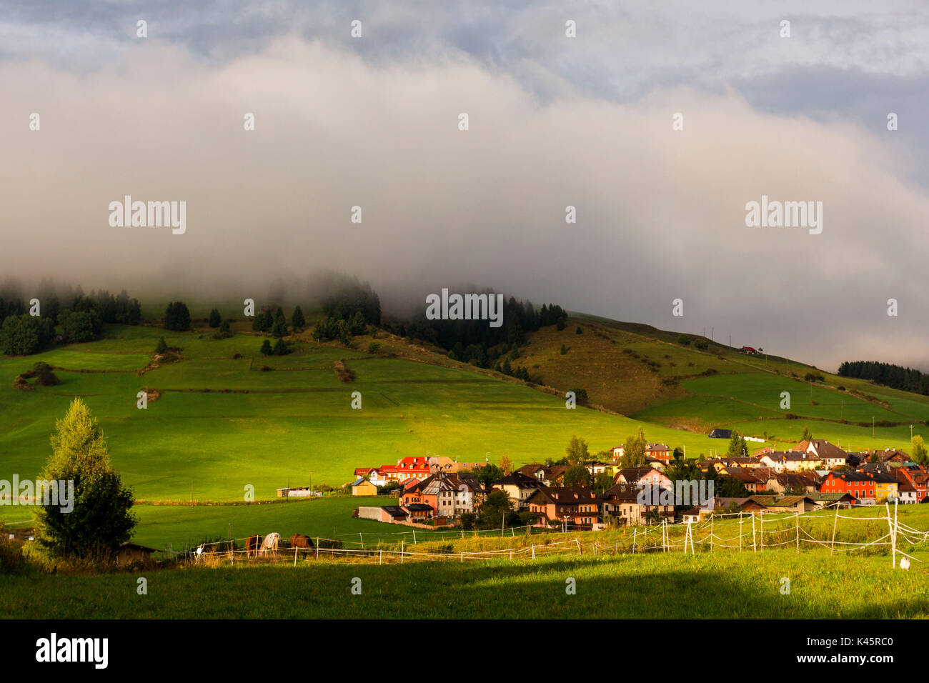 Zona residencial, Altopiano de Asiago, en la provincia de Vicenza, Veneto, Italia. Casas de campo con potreros de caballos. Foto de stock