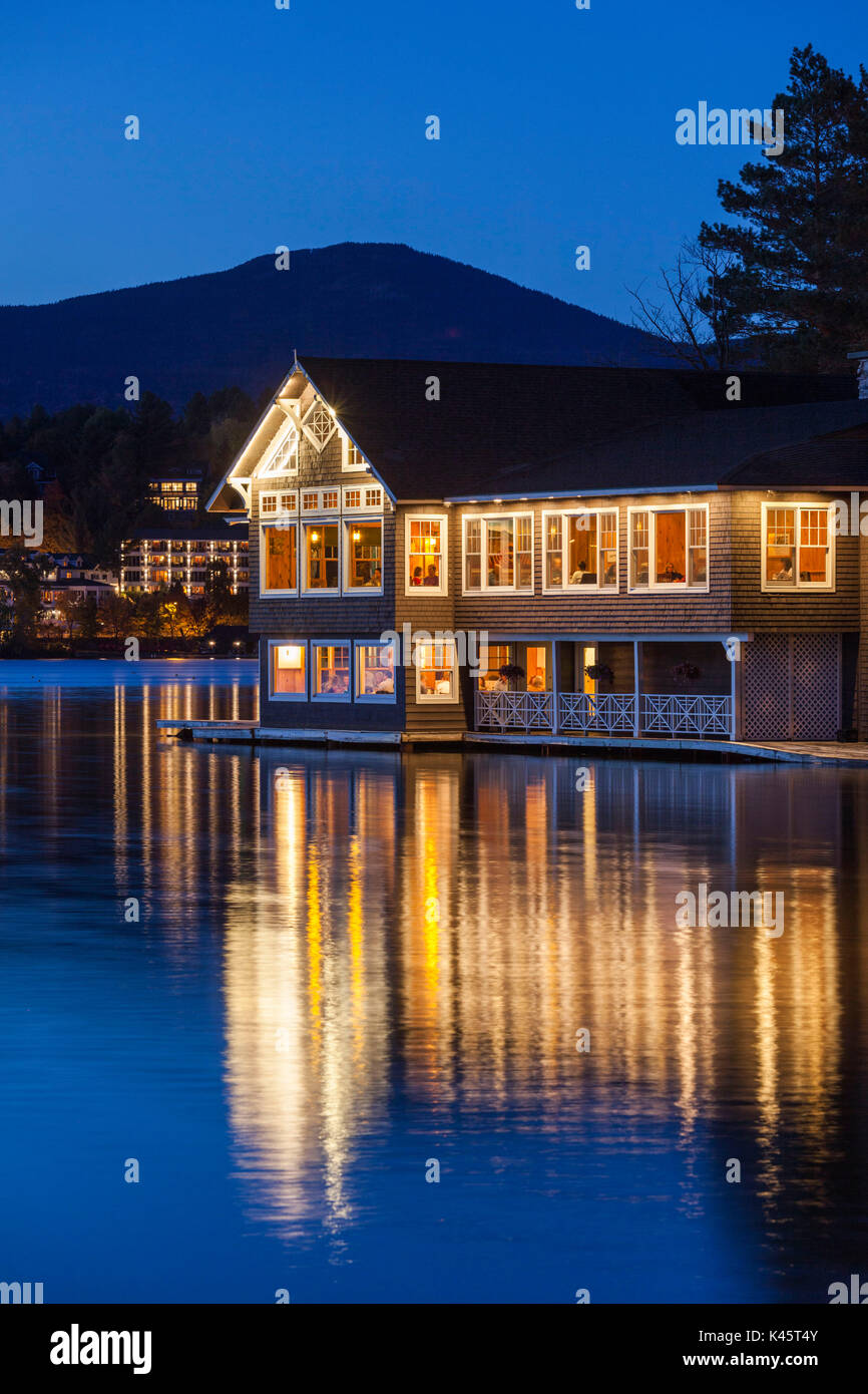 Los Estados Unidos, Nueva York, montañas Adirondack, Lake Placid, Lake Placid club boathouse, restaurante en el lago Espejo, el anochecer Foto de stock