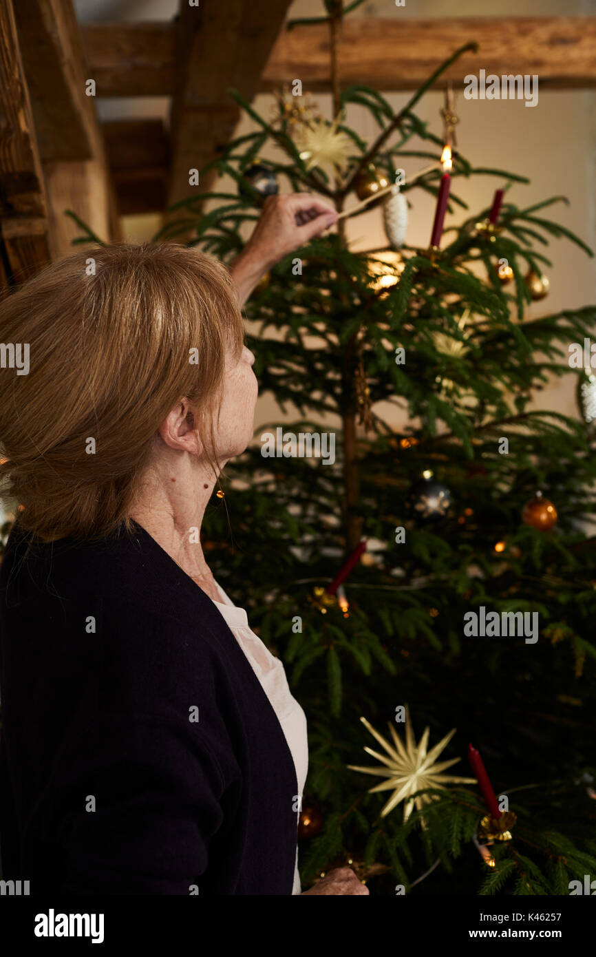 Mujer velas en las luces del árbol de Navidad, la víspera de Navidad Foto de stock