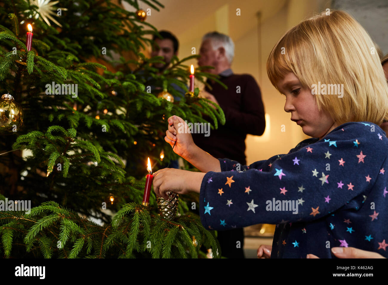 Niño decorando árbol de navidad en la víspera de Navidad Foto de stock