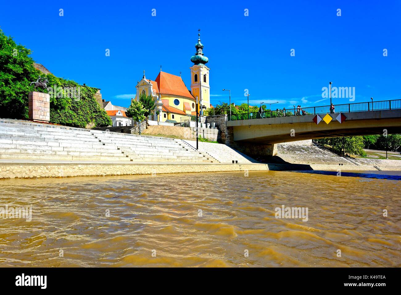 Río Raab con una vista de la Iglesia Carmelita en Gyor Foto de stock