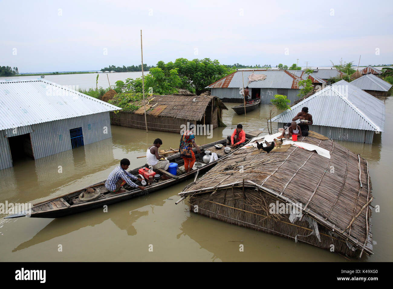 Pobladores refugiarse en el barco y el techo de la casa como su hogar sumergidos por las aguas de la inundación en ulipur en kurigram. La mayoría de las zonas del distrito de kurigram ulipur (en) Foto de stock