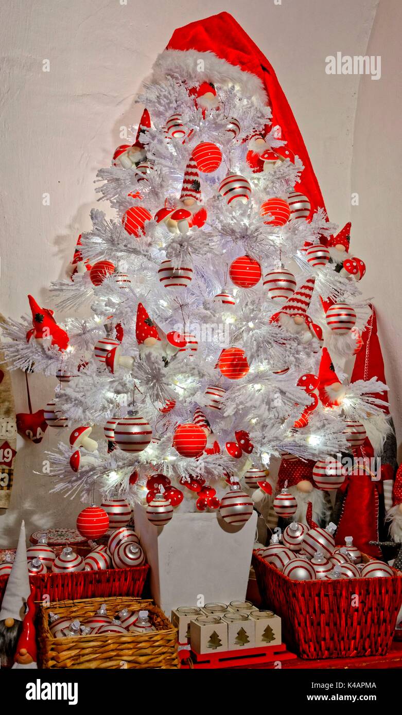 Árbol de navidad artificial en un elegante color blanco con rojo y esferas  de plata Fotografía de stock - Alamy