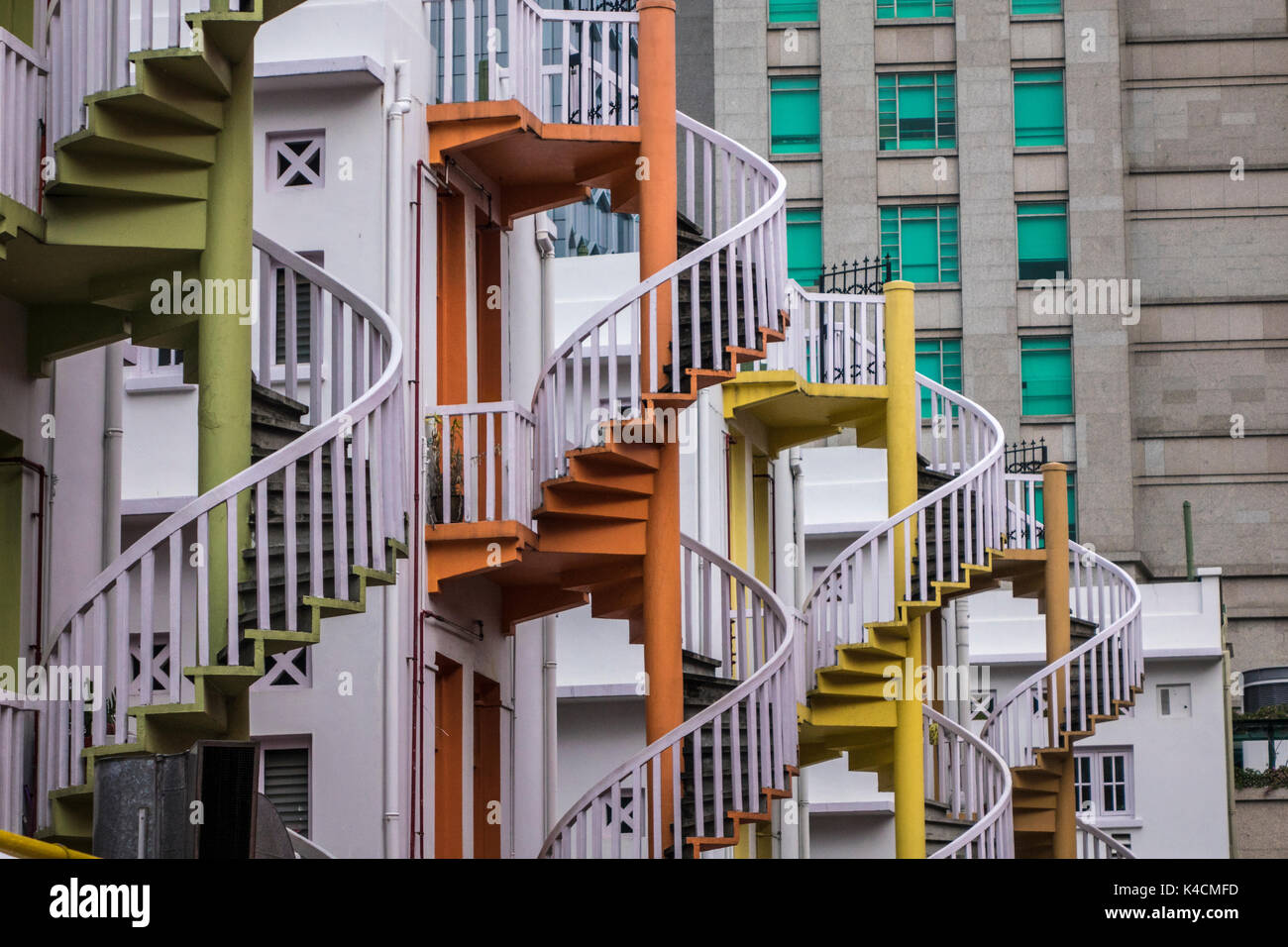 Los contrastes arquitectónicos, en primer plano juguetón escaleras en espiral en el fondo gris hormigón. Foto de stock