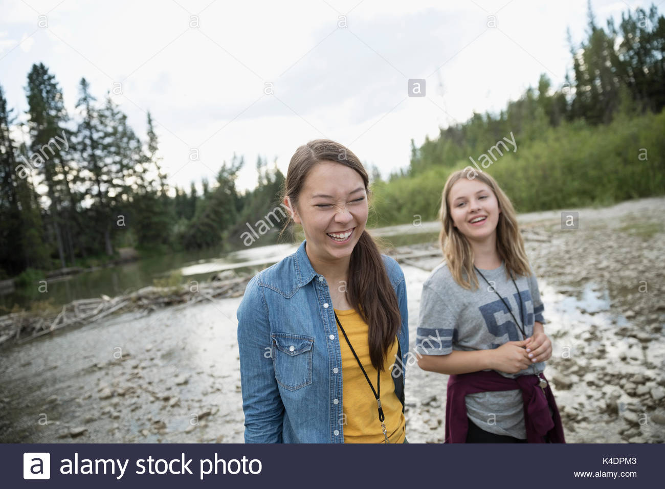 Laughing adolescente estudiante de escuela al aire libre amigos caminando por stream Foto de stock