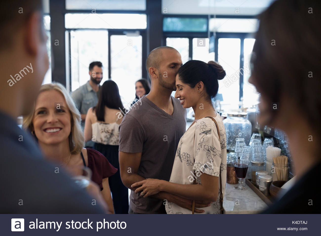 Afectuosa pareja besándose en bar Foto de stock