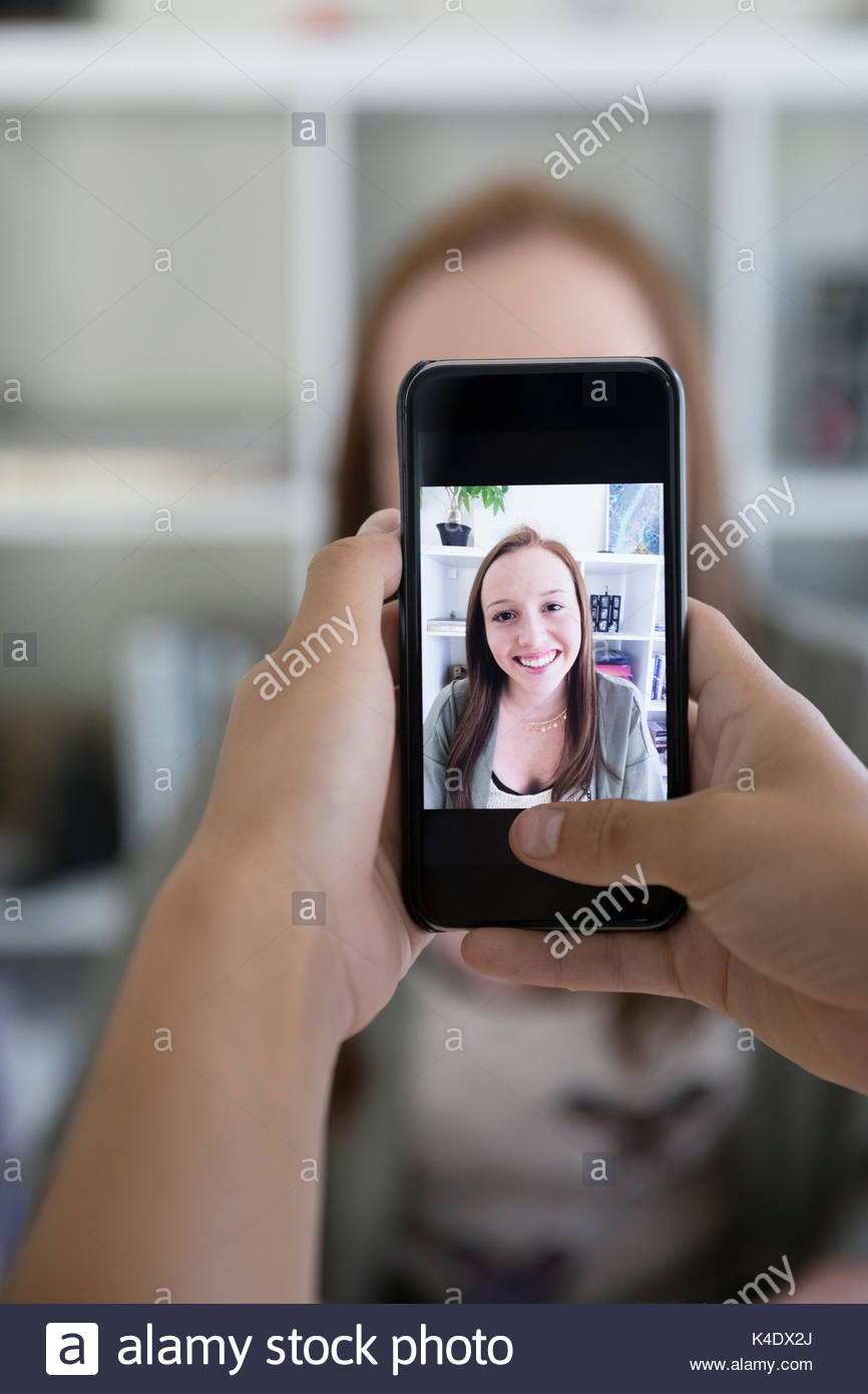 Perspectiva personal amigo fotografiando adolescente con cámara teléfono Foto de stock