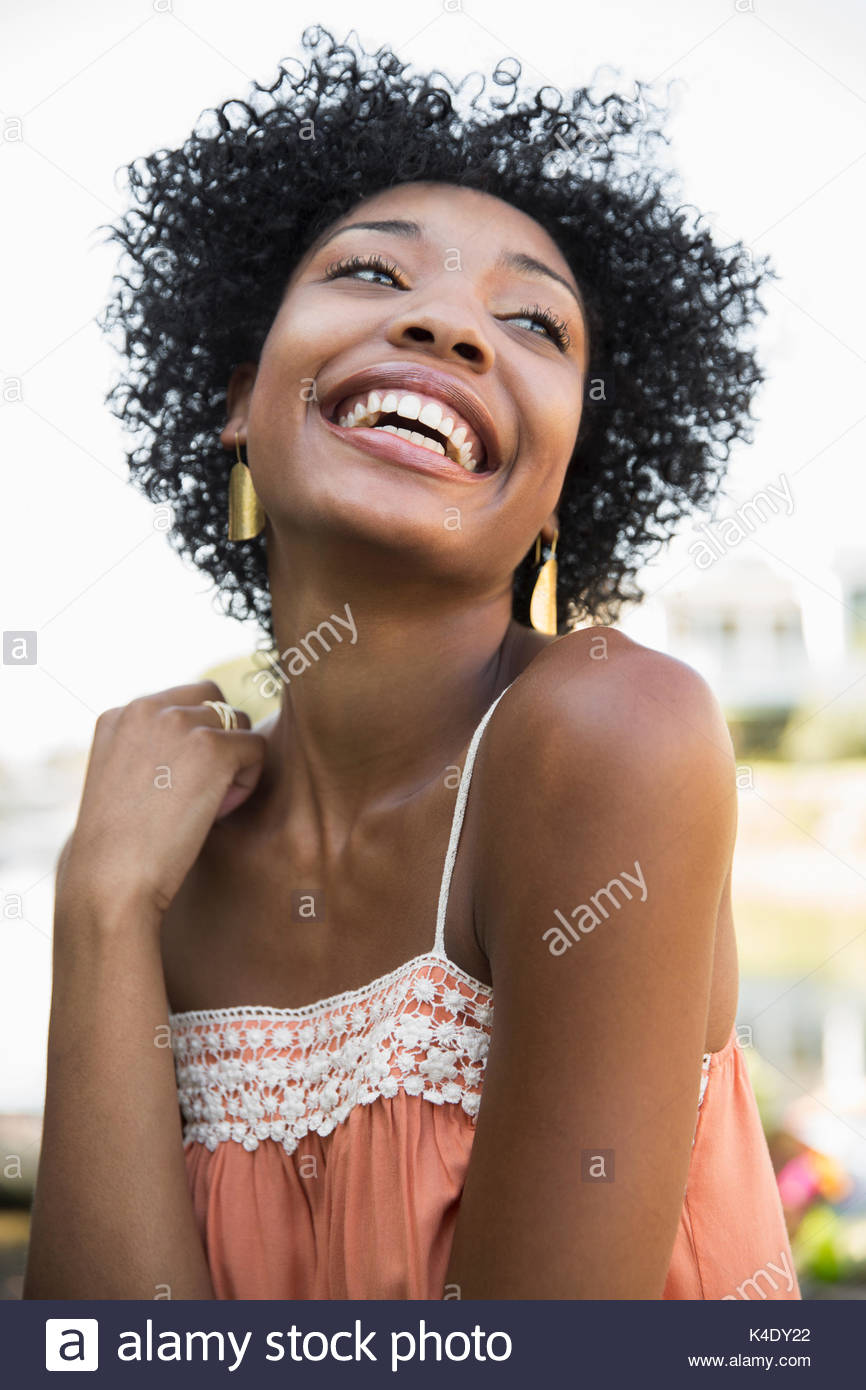 Retrato riendo joven afroamericana y de cabello negro y rizado Foto de stock