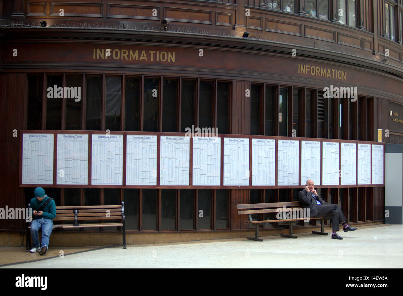 Paneles de madera en las tablas de información de trenes en la estación central de Glasgow concourse lateral Foto de stock