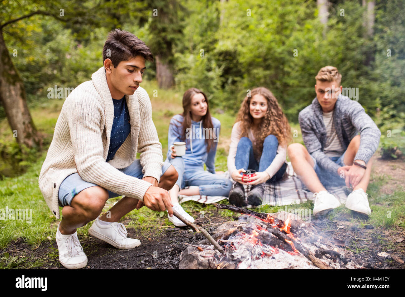 Los adolescentes acampar en la naturaleza, sentarse en la fogata