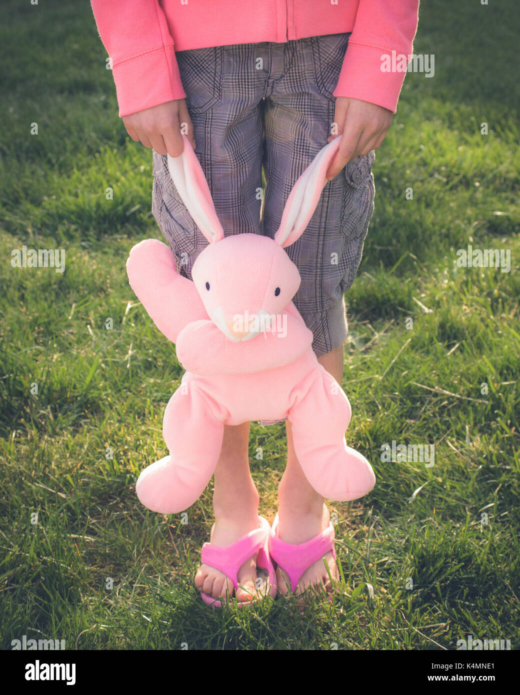 Una niña de 10 años abrazando y jugando con su peluche favorito. Foto de stock