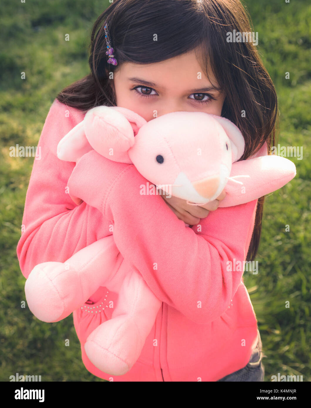 Niña jugando fuera de juguetes de peluche. Foto de stock