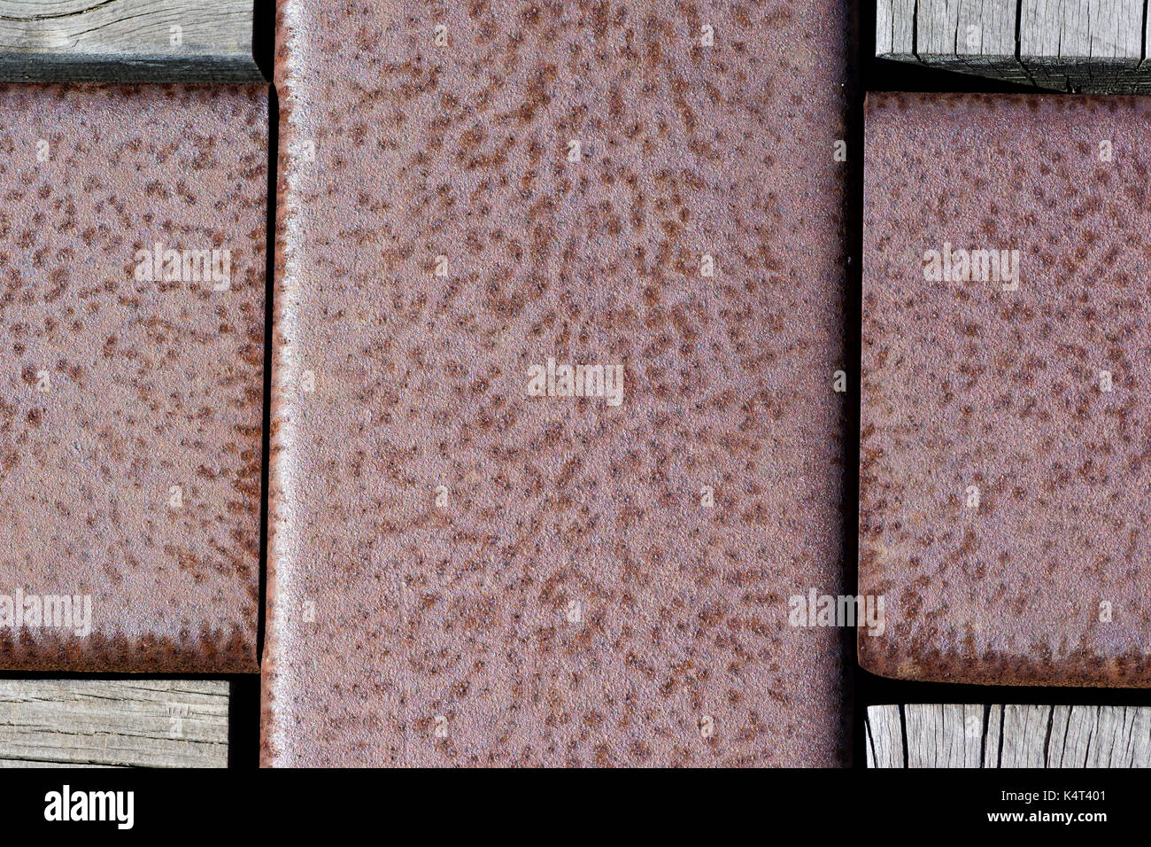 Texturas abstractas y antecedentes: La corrosión metálica sección transversal con bloques de madera en las esquinas. parte de un puente de pie piso. Foto de stock