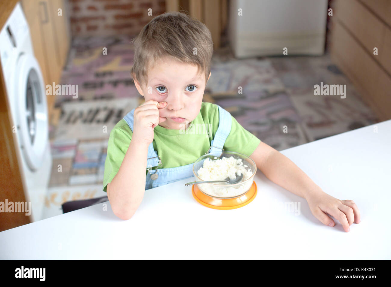 Niño con comida en la mesa Foto de stock