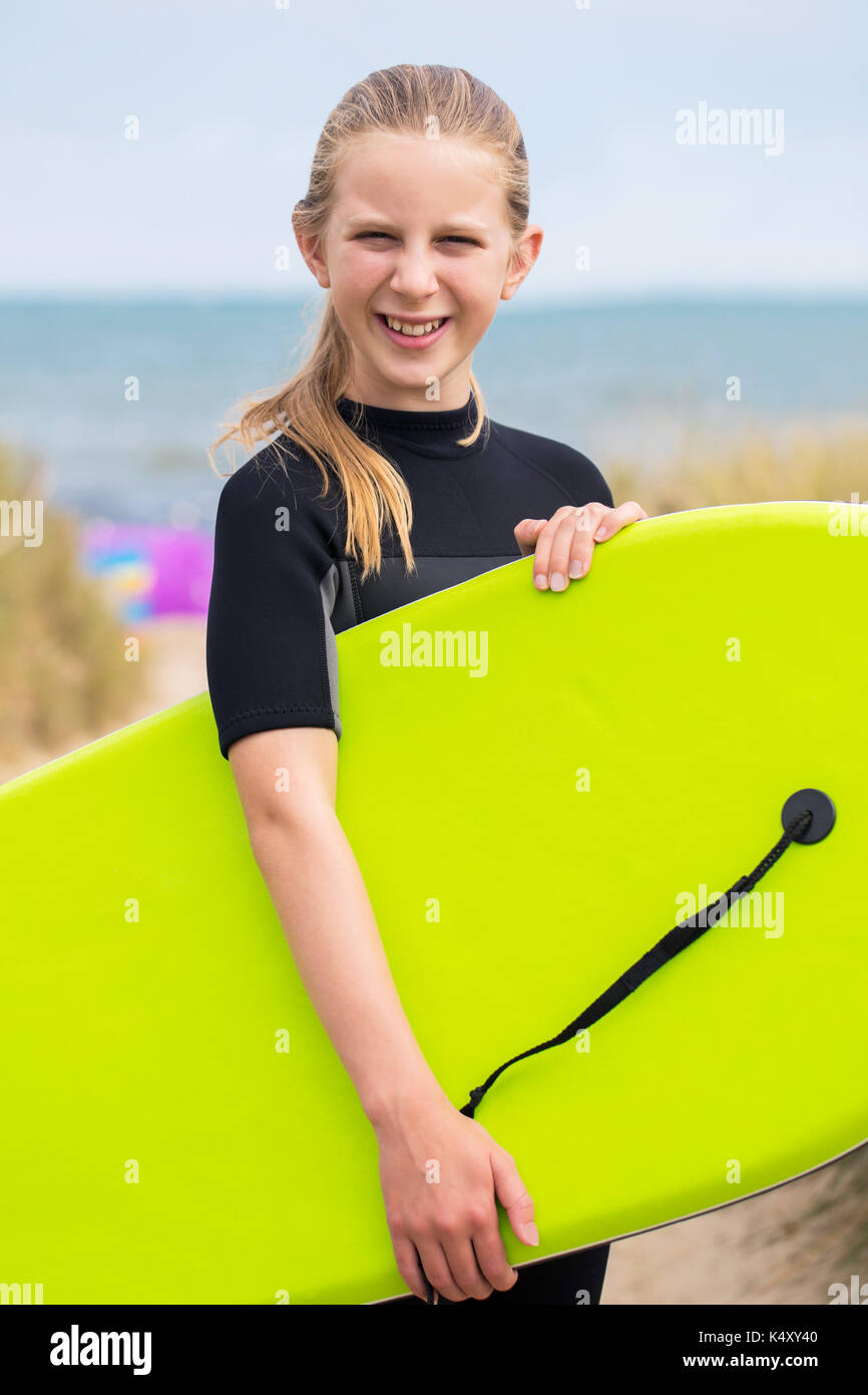 Retrato de niña por mar en traje celebración bodyboard Fotografía de stock  - Alamy