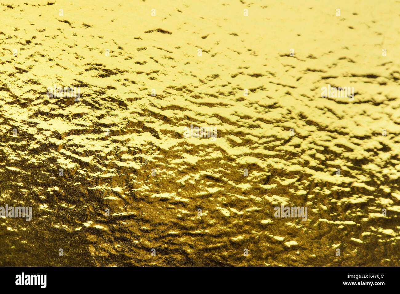El oro brillante de textura de una lámina de fondo. Una hoja de papel  brillante de color dorado Fotografía de stock - Alamy