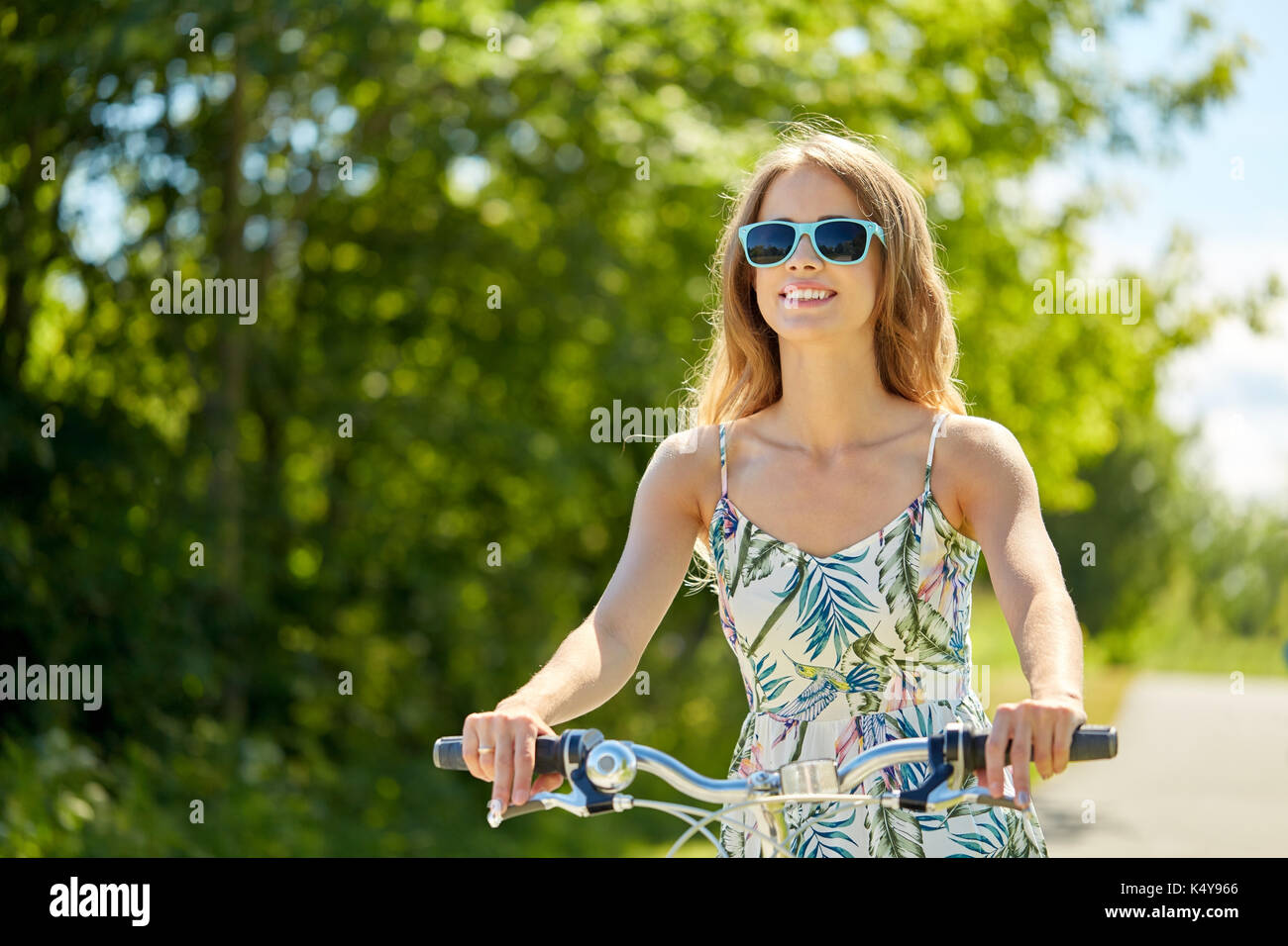 belleza de verano. mujer joven atractiva en ropa casual manteniendo la mano  en el cabello mientras anda en bicicleta al aire libre 13487709 Foto de  stock en Vecteezy