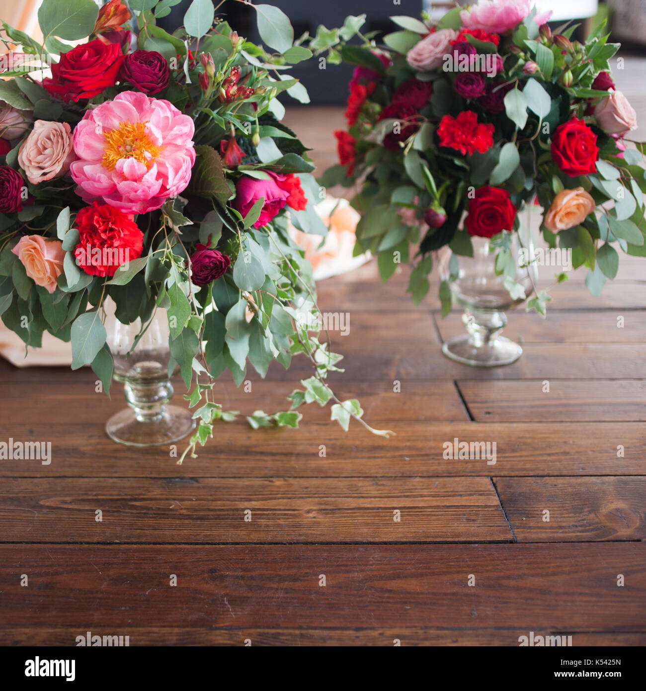 Los Floreros con ramos de flores rojas de fondo de madera en el suelo  Fotografía de stock - Alamy