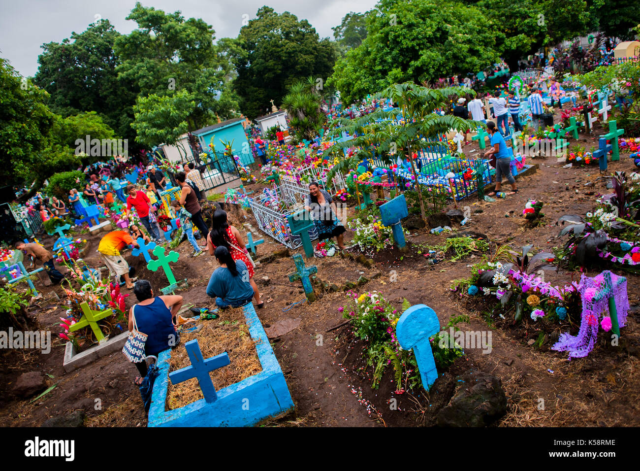 Las familias salvadoreñas se reúnen en las tumbas decoradas con flores