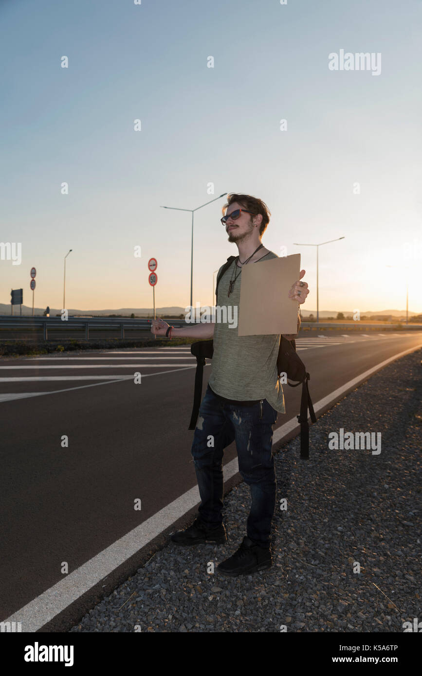 Hombre de 21 años en una autopista hitchhikikng Foto de stock