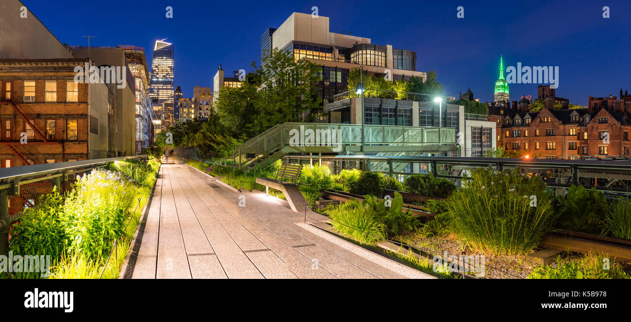 Vista panorámica de la High Line paseo al atardecer con las luces de la ciudad y rascacielos iluminados. Chelsea, Manhattan, Ciudad de Nueva York Foto de stock