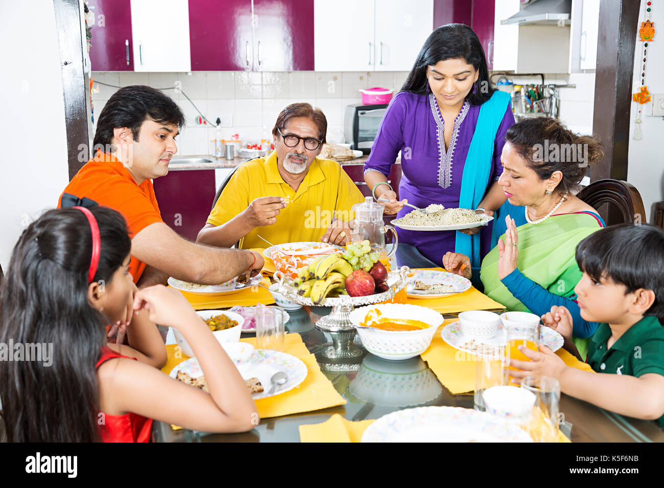 Gran Familia una mesa para comer mujer sirviendo comida Cena Comedor Foto de stock