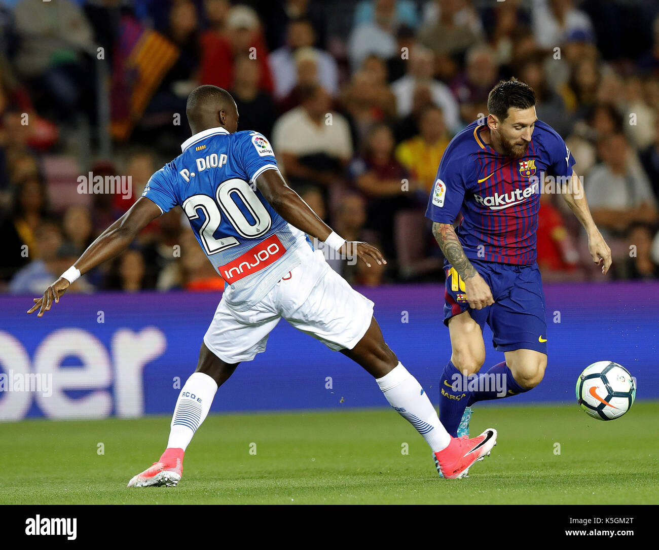 Delantero del FC Barcelona Lionel Messi (R) y RCD Espanyol de Pape Diop (R)  compiten por la bola durante la tercera ronda de la Liga de Santander  coincide en que ambos equipos