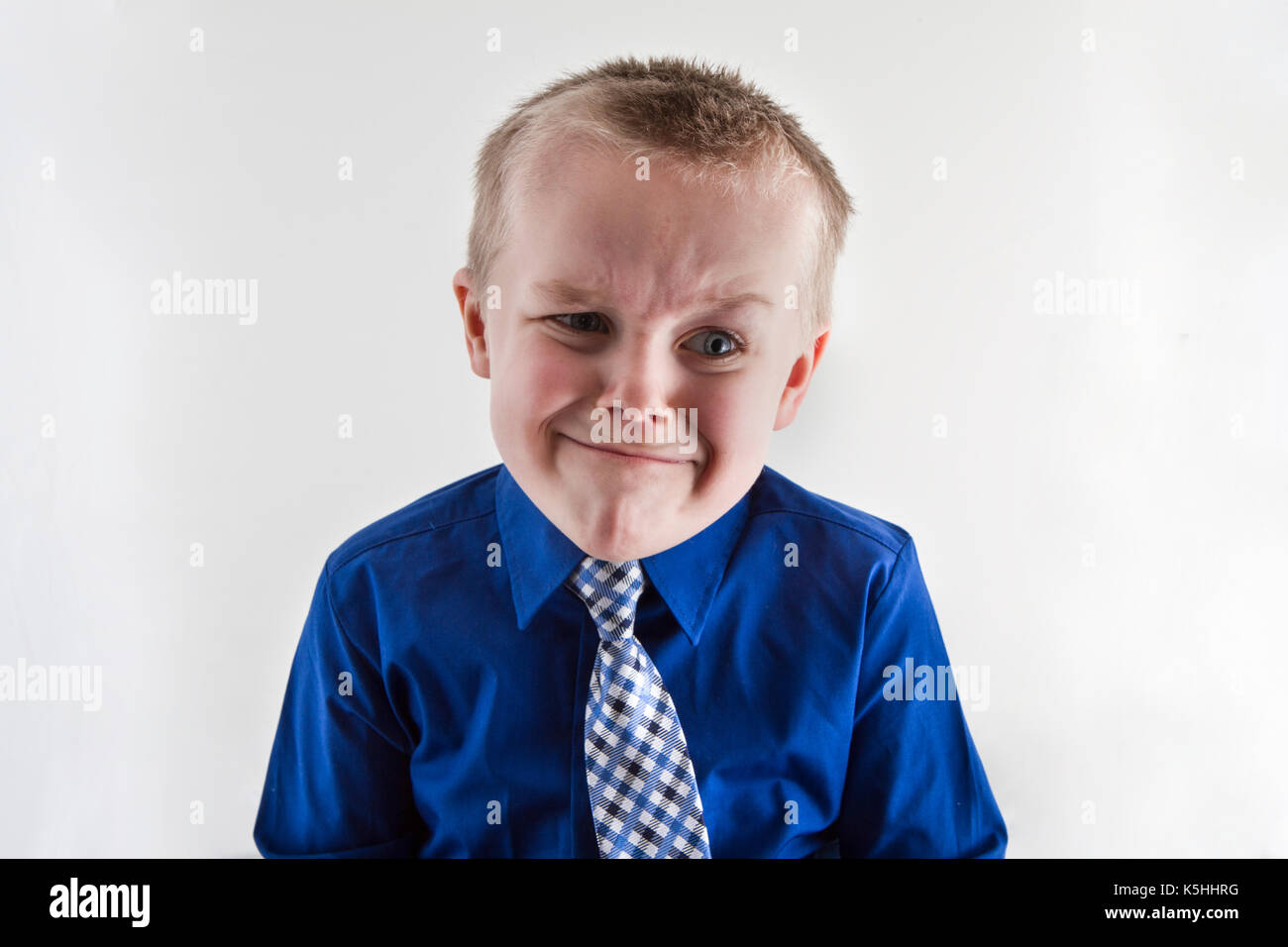 Boy haciendo una divertida expresión en su rostro mientras vestido con un  traje y corbata Fotografía de stock - Alamy