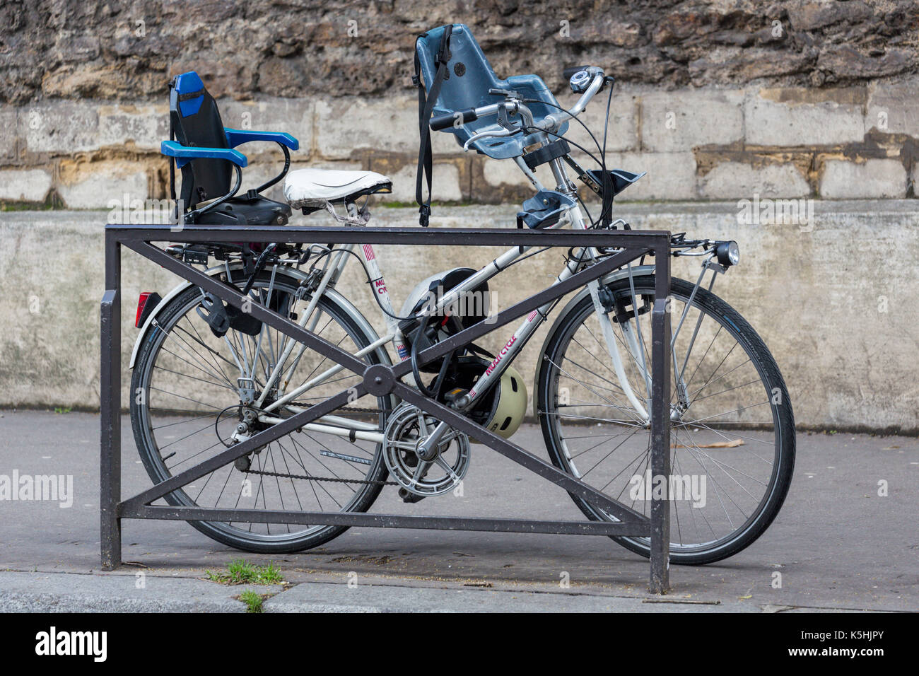 Bicicleta con dos asientos para niños encadenados a una barandilla en la  calle en París Fotografía de stock - Alamy