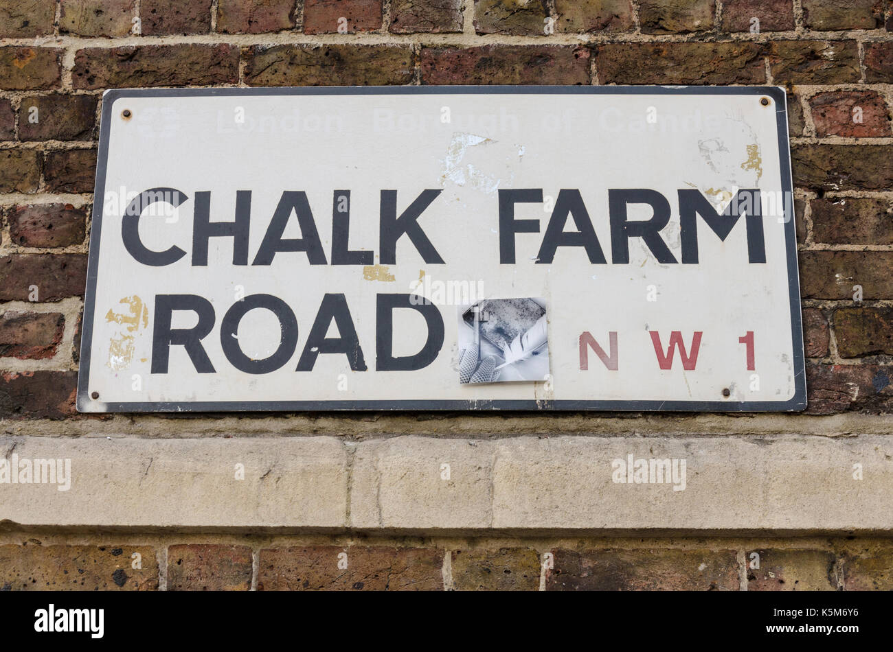 Un cartel con el nombre de la calle para 'Chalk Farm Road' en una pared de ladrillo Foto de stock